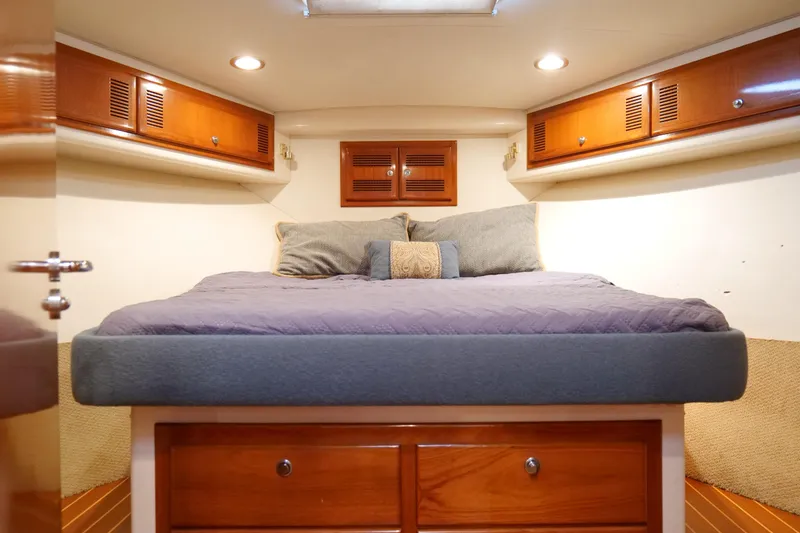 Slide: The Image of Luxurious cabin interior of 1998 Cabo 45 Express yacht with cozy bedding and wooden cabinets. - 30