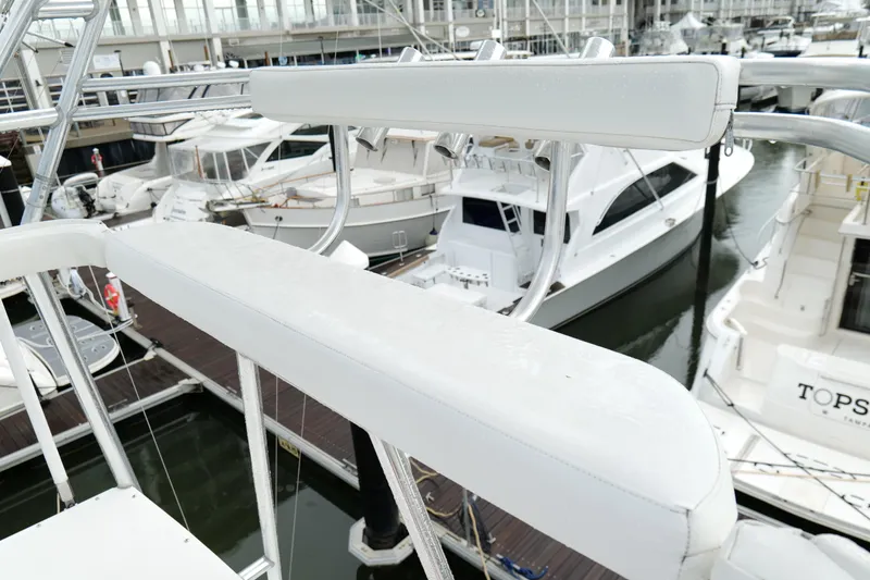 Slide: The Image of 1998 Cabo 45 Express yacht docked at marina, surrounded by other boats. - 38