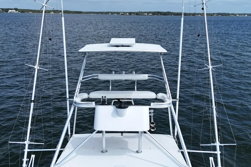 Slide: The Image of 1998 Cabo 45 Express boat on calm water with fishing rods. - 39