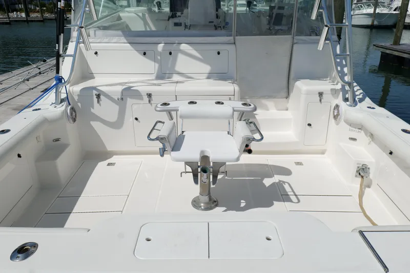 Slide: The Image of 1998 Cabo 45 Express boat cockpit with fishing chair and storage compartments. - 42
