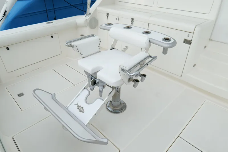 Slide: The Image of Fishing chair on 1998 Cabo 45 Express yacht deck, featuring rod holders and white upholstery. - 43