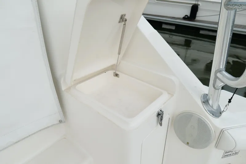 Slide: The Image of Storage compartment on a 1998 Cabo 45 Express boat, featuring a white interior and speaker. - 47