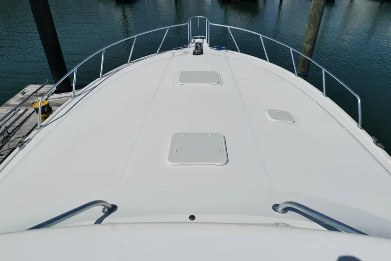 Slide: The Image of Bow view of a 1998 Cabo 45 Express yacht docked at a marina. - 48