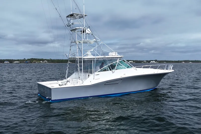 Slide: The Image of 1998 Cabo 45 Express boat on open water under cloudy skies. - 6