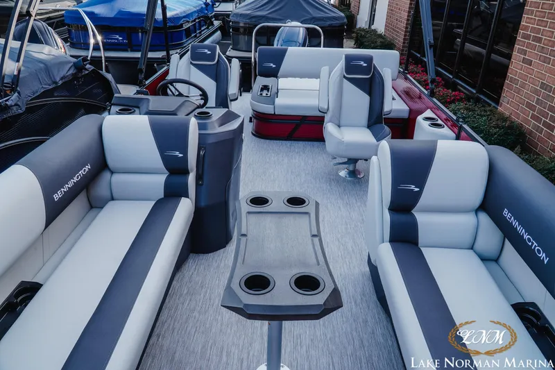Slide: The Image of 2026 Bennington 22SSB pontoon boat interior with plush seating and cup holders at Lake Norman Marina. - 11