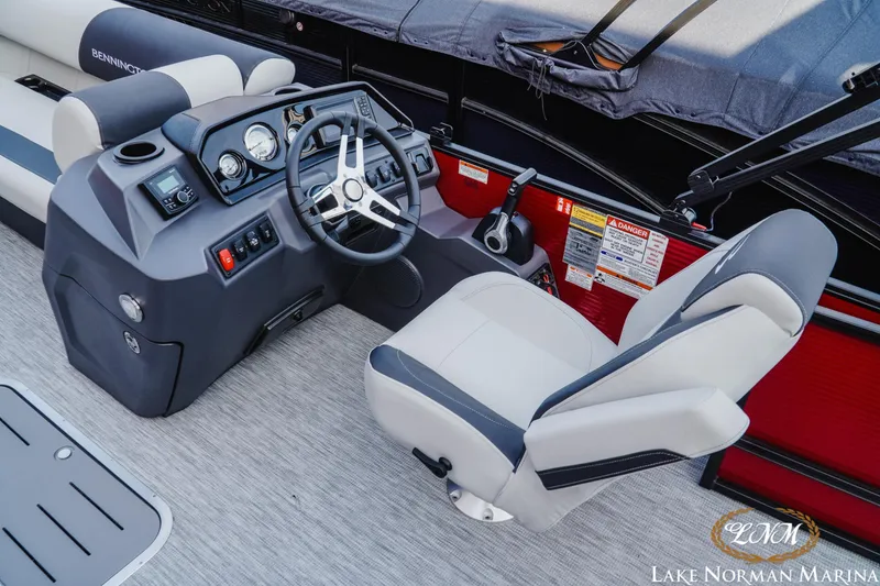 Slide: The Image of 2026 Bennington 22SSB boat interior with steering wheel and captain's chair at Lake Norman Marina. - 7