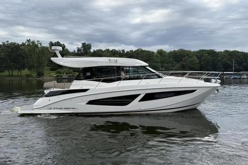 The Image of 2017 Regal 42 Grande Coupe yacht cruising on a calm lake under cloudy skies. - 0