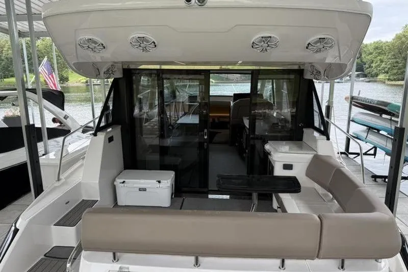 Slide: The Image of 2017 Regal 42 Grande Coupe yacht with spacious seating and modern design docked by a lake. - 29