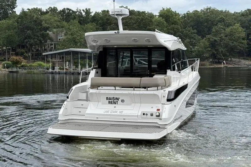Slide: The Image of 2017 Regal 42 Grande Coupe yacht on a lake, rear view with trees in background. - 7