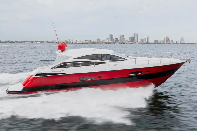 Slide: The Image of 2007 Pershing 56 yacht cruising on water with city skyline in background. - 2
