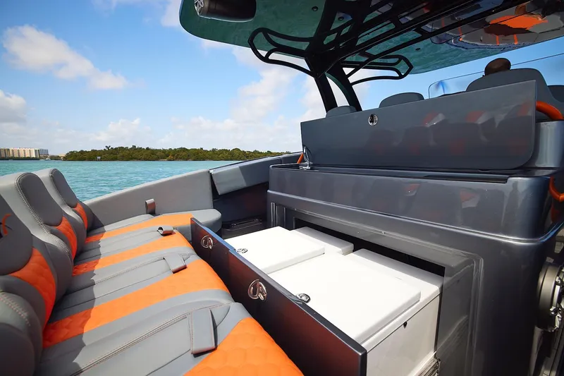 Slide: The Image of 2022 Midnight Express 43 Open boat interior with orange and gray seating, open storage compartments. - 16