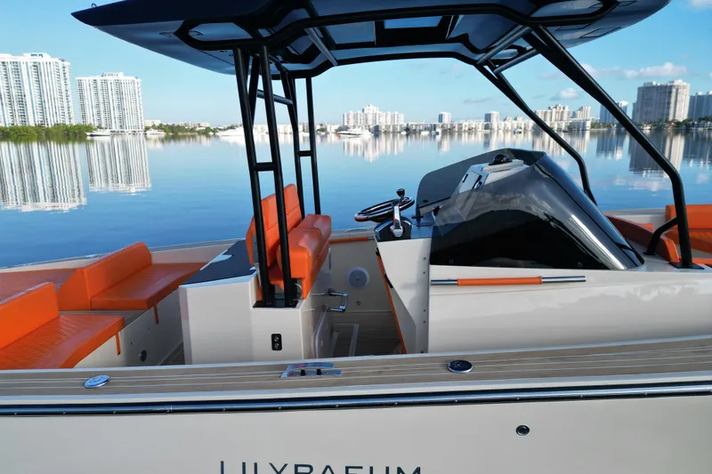 Slide: The Image of 2026 Lilybaeum Lipari 31 boat with orange seating, sleek design, and waterfront cityscape. - 24