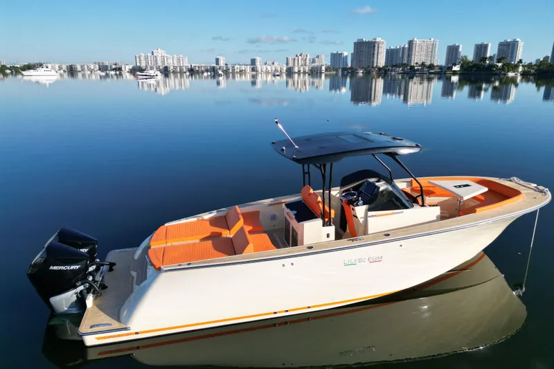 Slide: The Image of 2026 Lilybaeum Lipari 31 boat on calm water with city skyline in background. - 4