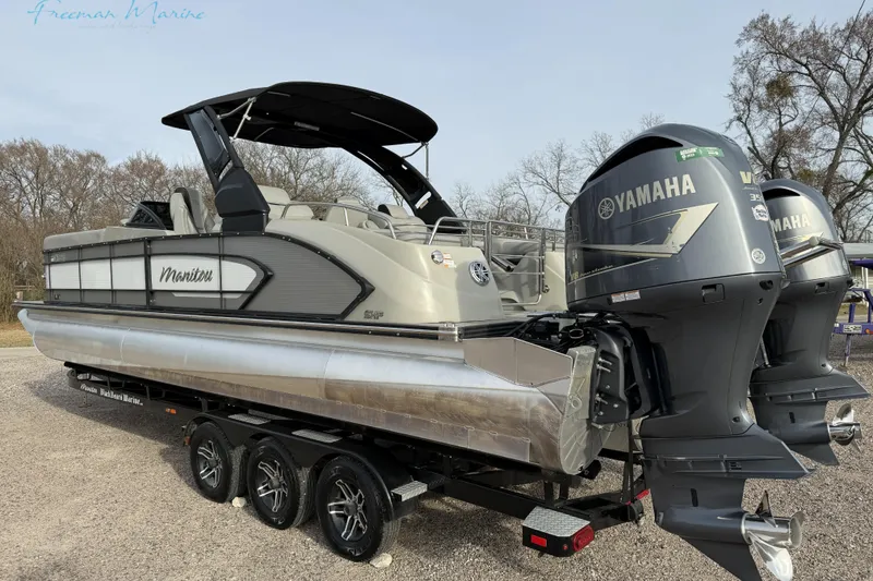 The Image of 2022 Manitou 27 LX SRW pontoon boat with dual Yamaha outboard engines on a trailer. - 0