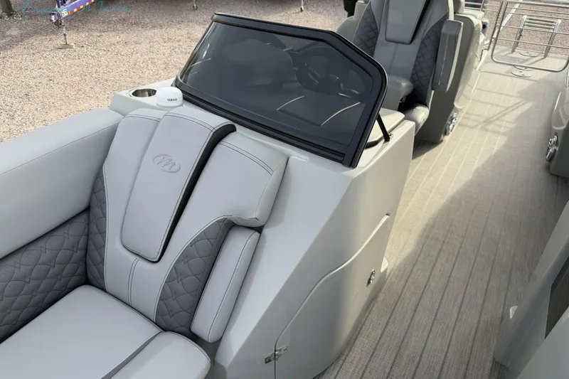 Slide: The Image of 2022 Manitou 27 LX SRW boat interior with gray seating and console. - 12