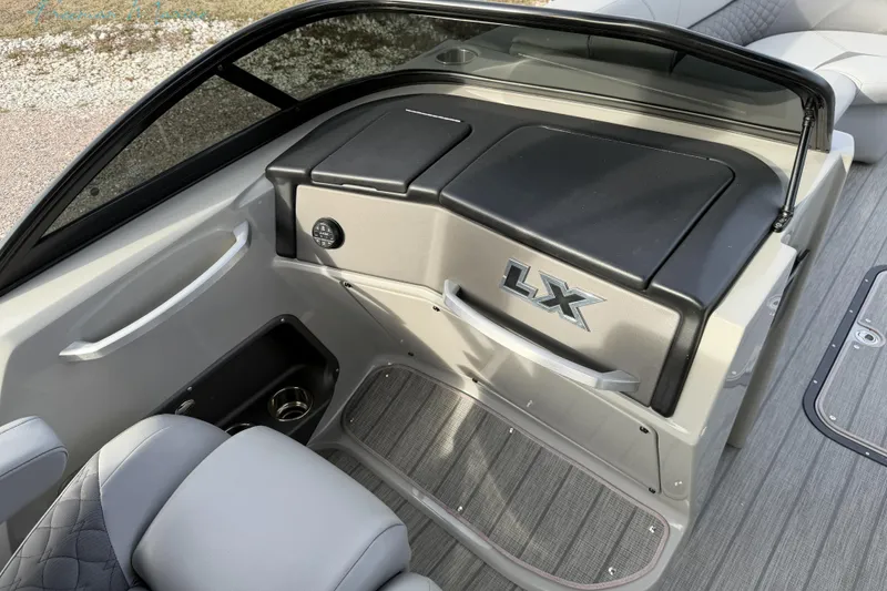 Slide: The Image of 2022 Manitou 27 LX SRW boat interior with sleek dashboard and seating. - 17