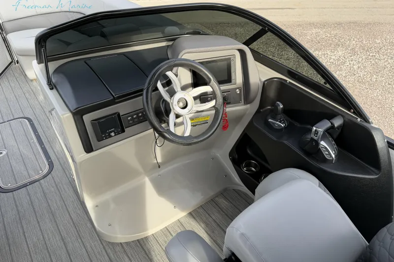 Slide: The Image of Cockpit of 2022 Manitou 27 LX SRW boat with steering wheel and controls. - 18