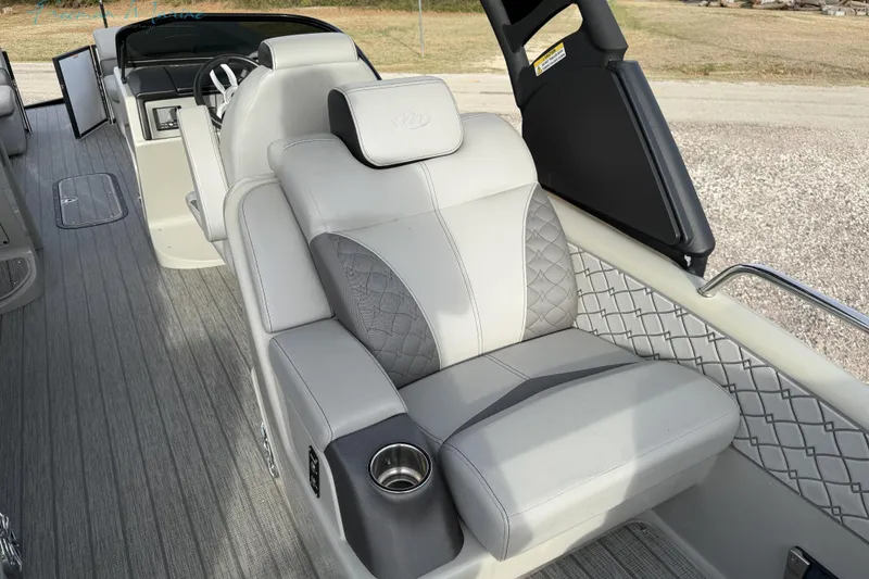 Slide: The Image of Luxurious seating on 2022 Manitou 27 LX SRW pontoon boat with quilted upholstery and cup holder. - 21