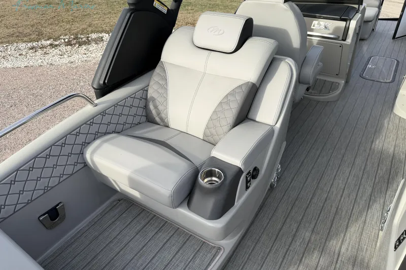 Slide: The Image of Luxurious seating on 2022 Manitou 27 LX SRW boat with elegant upholstery and cup holder. - 24