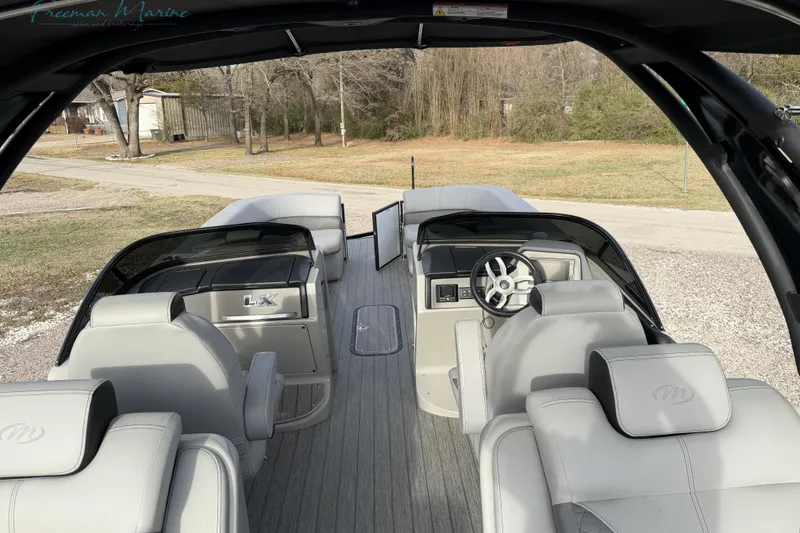 Slide: The Image of 2022 Manitou 27 LX SRW pontoon boat interior with sleek seating and modern dashboard. - 25
