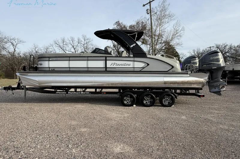 Slide: The Image of 2022 Manitou 27 LX SRW pontoon boat on trailer, side view, outdoors. - 3