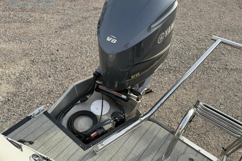 Slide: The Image of 2022 Manitou 27 LX SRW with Yamaha V8 outboard motor on gravel surface. - 31