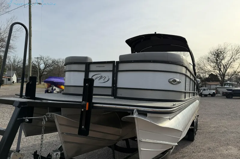 Slide: The Image of 2022 Manitou 27 LX SRW pontoon boat on trailer in outdoor setting. - 4
