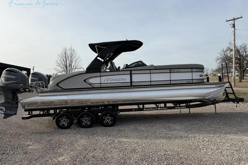 Slide: The Image of 2022 Manitou 27 LX SRW pontoon boat on trailer, featuring Yamaha engines. - 5