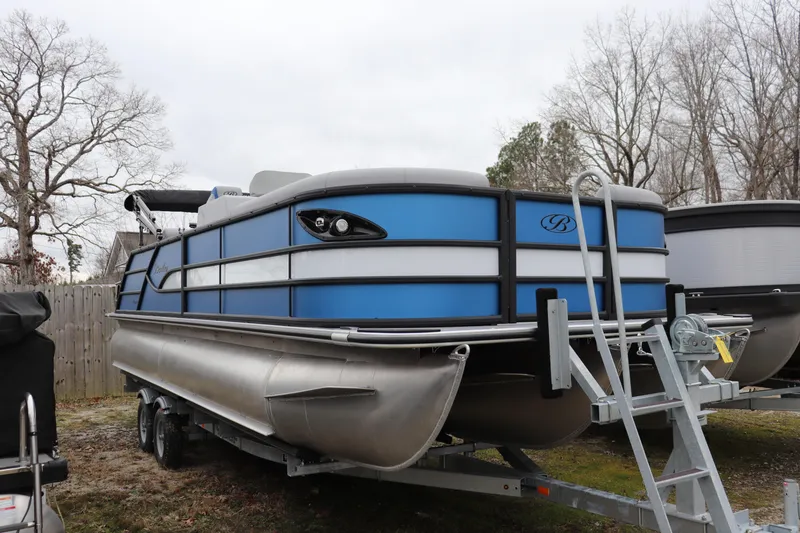 The Image of 2026 Bentley Pontoons Legacy 243 QSB on trailer, blue and silver design, parked outdoors. - 0