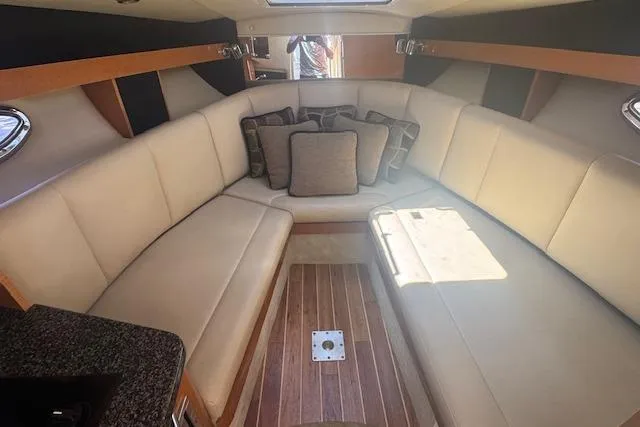 Slide: The Image of Interior of 2011 Chaparral 270 Signature boat with beige seating and wooden flooring. - 12