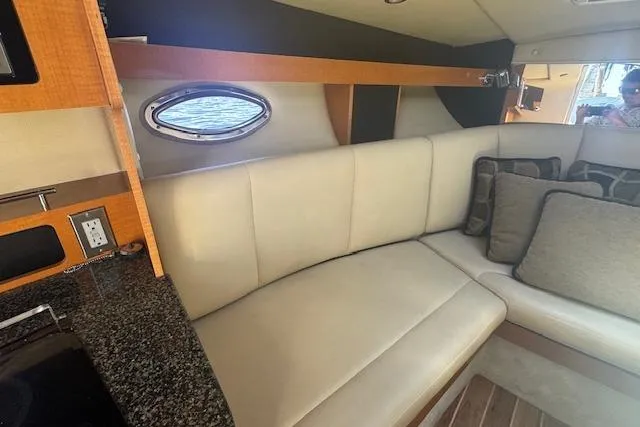 Slide: The Image of Interior of 2011 Chaparral 270 Signature boat with beige seating and granite countertop. - 13