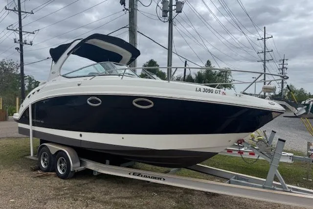 Slide: The Image of 2011 Chaparral 270 Signature boat on trailer, parked outdoors under cloudy sky. - 20