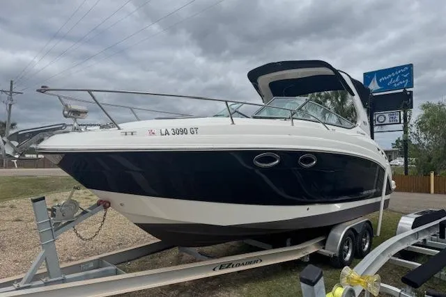 Slide: The Image of 2011 Chaparral 270 Signature boat on trailer, parked outdoors under cloudy sky. - 24