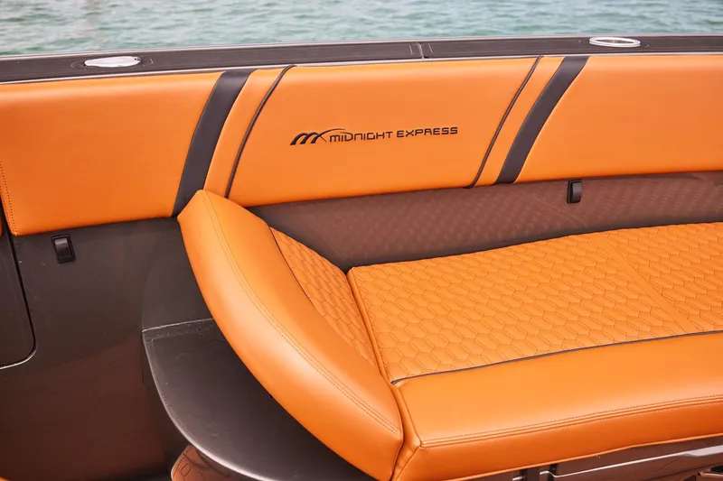Slide: The Image of Luxurious orange seating on 2024 Midnight Express 43 Solstice boat, featuring elegant stitching and branding. - 13