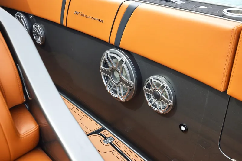 Slide: The Image of Interior of 2024 Midnight Express 43 Solstice boat with premium speakers and orange seating. - 14