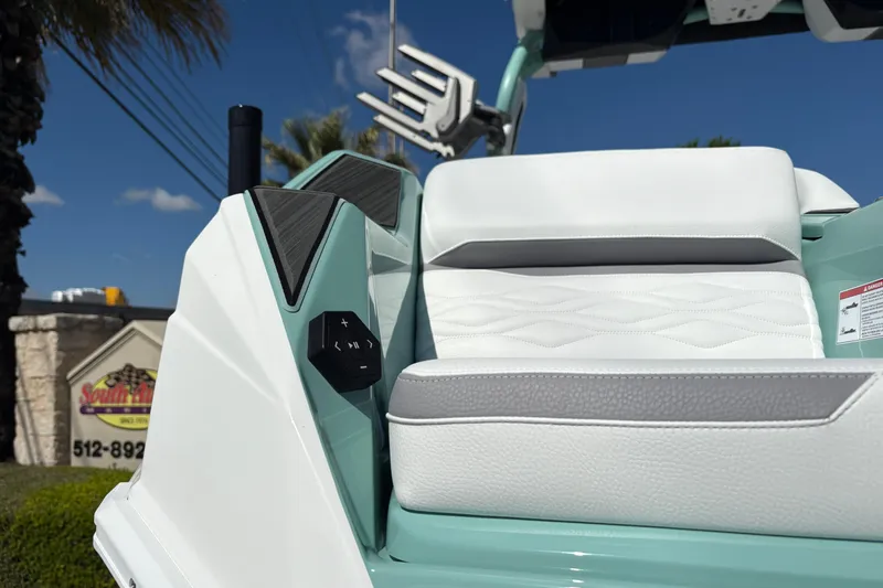 Slide: The Image of 2026 Supra SA 550 boat seat with white upholstery and control panel, under clear blue sky. - 10