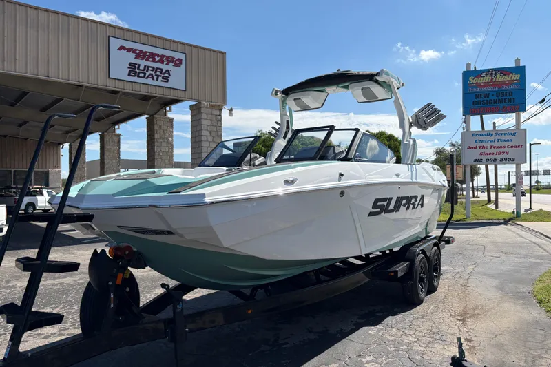 Slide: The Image of 2026 Supra SA 550 boat on trailer at dealership, sunny day. - 4