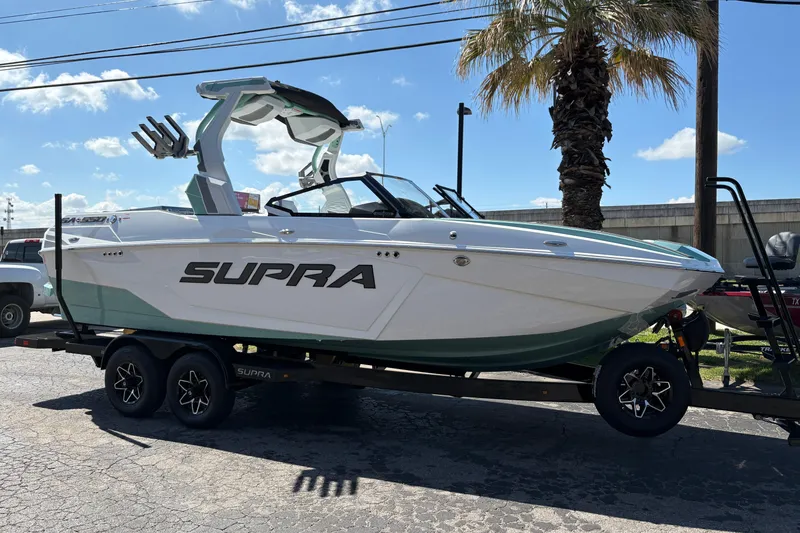 Slide: The Image of 2026 Supra SA 550 boat on trailer, parked outdoors under clear sky. - 42