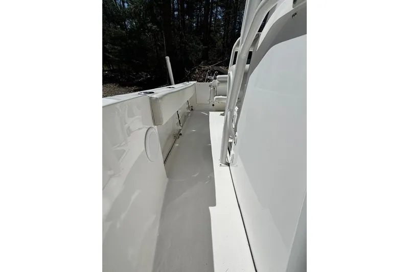 Slide: The Image of 2021 Edgewater 208CC boat interior, showcasing sleek white deck and seating area. - 13