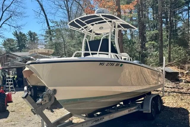 Slide: The Image of 2021 Edgewater 208CC boat on trailer in wooded area, sunny day. - 2