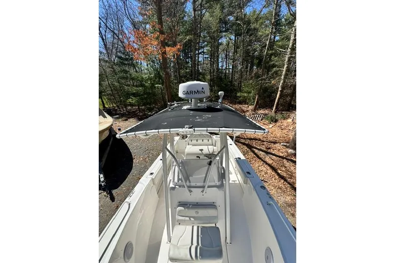 Slide: The Image of 2021 Edgewater 208CC boat with Garmin equipment, parked in a wooded area. - 21