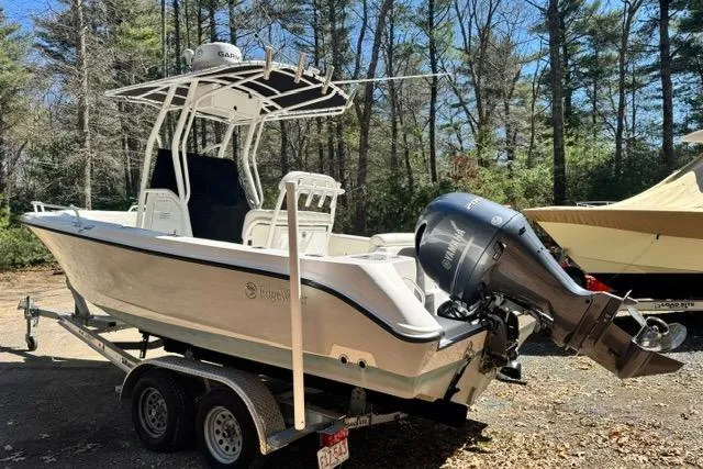 Slide: The Image of 2021 Edgewater 208CC boat on trailer in wooded area. - 4