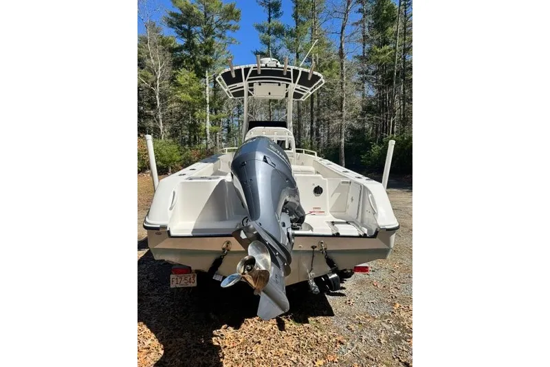 Slide: The Image of 2021 Edgewater 208CC boat with outboard motor in a wooded area. - 5