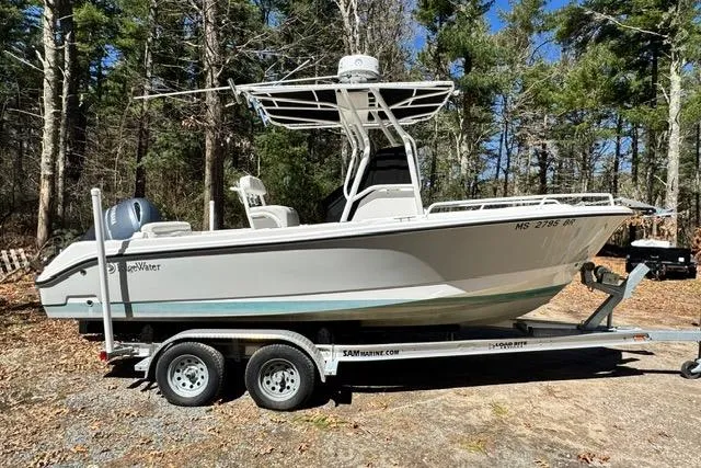 Slide: The Image of 2021 Edgewater 208CC boat on trailer in wooded area, sunny day. - 7