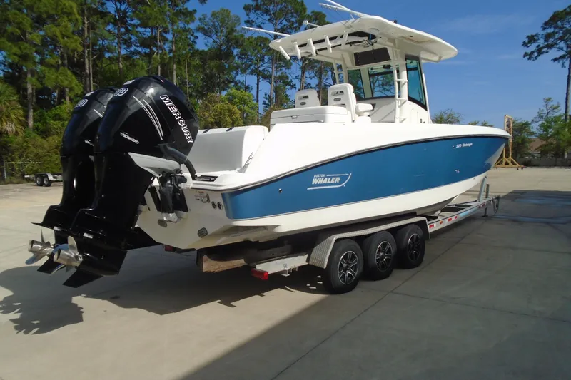 The Image of 2011 Boston Whaler 330 Outrage boat on trailer, featuring dual Mercury engines. - 0