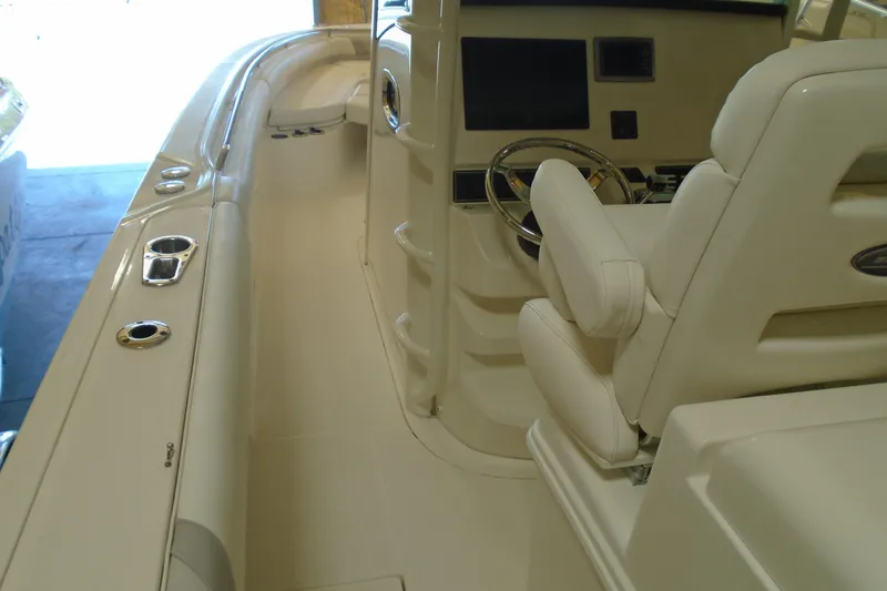 Slide: The Image of Interior view of a 2011 Boston Whaler 330 Outrage boat, featuring helm and seating area. - 11