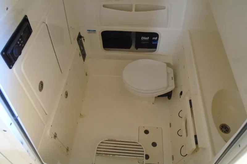 Slide: The Image of Interior of 2011 Boston Whaler 330 Outrage boat featuring a compact marine toilet. - 16