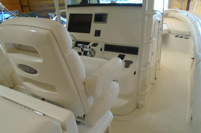 Slide: The Image of Interior view of a 2011 Boston Whaler 330 Outrage boat, showcasing helm and seating area. - 12