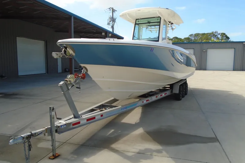 Slide: The Image of 2011 Boston Whaler 330 Outrage boat on trailer, parked outside a warehouse. - 3
