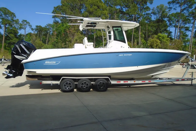 Slide: The Image of 2011 Boston Whaler 330 Outrage boat on trailer, parked outdoors. - 6